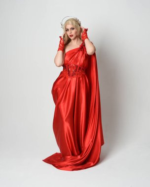 Full length portrait of beautiful blonde model dressed as ancient mythological fantasy goddess in flowing red silk toga gown, crown. elegant dancing pose with flowing fabric,  isolated on white studio background. clipart
