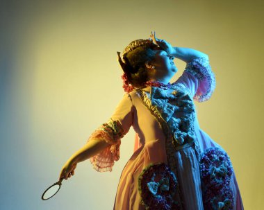  Gösterişli pembe bir elbise giyen kadın modelin sinematik portresi, tarihi bir Fransız barok asaleti kostümü, Marie Antoinette tarzı. Stüdyonun arka planında el aynası var..