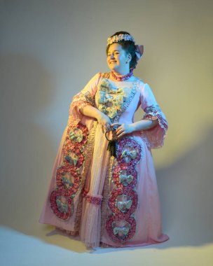 Gösterişli pembe bir elbise giyen kadın modelin sinematik portresi, tarihi bir Fransız barok asaleti kostümü, Marie Antoinette tarzı. Anahtar halkası, stüdyo arka planında izole edilmiş.