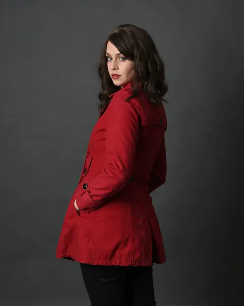 Güzel Esmer Kadın Modelinin Kırmızı Trençkot Ceketli Portresi Karanlık Stüdyo - Stok İmaj