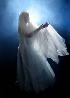 Ortaçağ masal elbisesi giymiş güzel sarışın fantezi perisi, peçeli beyaz kapüşonlu bir pelerin. dumanlı sis efektiyle izole edilmiş karanlık stüdyo arkaplanı