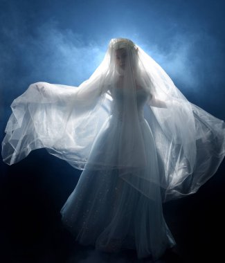 Ortaçağ masal elbisesi giymiş güzel sarışın fantezi perisi, peçeli beyaz kapüşonlu bir pelerin. dumanlı sis efektiyle izole edilmiş karanlık stüdyo arkaplanı