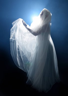 Ortaçağ masal elbisesi giymiş güzel sarışın fantezi perisi, peçeli beyaz kapüşonlu bir pelerin. dumanlı sis efektiyle izole edilmiş karanlık stüdyo arkaplanı