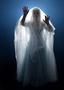 Ortaçağ masal elbisesi giymiş güzel sarışın fantezi perisi, peçeli beyaz kapüşonlu bir pelerin. dumanlı sis efektiyle izole edilmiş karanlık stüdyo arkaplanı