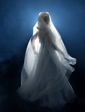 Ortaçağ masal elbisesi giymiş güzel sarışın fantezi perisi, peçeli beyaz kapüşonlu bir pelerin. dumanlı sis efektiyle izole edilmiş karanlık stüdyo arkaplanı