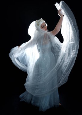 Ortaçağ masal elbisesi giymiş güzel sarışın fantezi perisi, peçeli beyaz kapüşonlu bir pelerin. Ayakta duruş karanlık stüdyo 