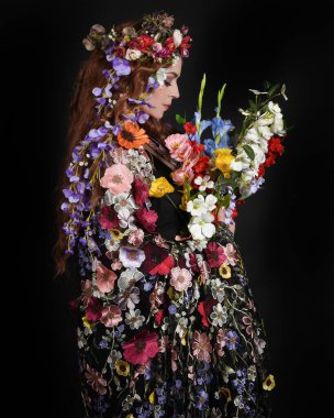 Celtic Bahar Tanrıçası Olarak Kadın Modellerinin Stüdyo Portreleri, Beltane Pagan Mitolojisinden esinlenilmiş Çiçek Fantezi Kostümleri, geri dönüp bakmaktadır. izole Karanlık Stüdyo Arkaplanı