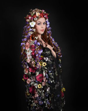 Celtic Bahar Tanrıçası Olarak Kadın Modellerinin Stüdyo Portreleri, Beltane Pagan Mitolojisinden esinlenilmiş Çiçek Fantezi Kostümleri, geri dönüp bakmaktadır. izole Karanlık Stüdyo Arkaplanı