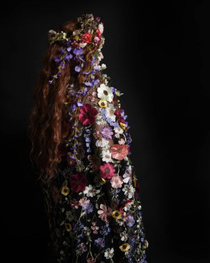 Celtic Bahar Tanrıçası Olarak Kadın Modellerinin Stüdyo Portreleri, Beltane Pagan Mitolojisinden esinlenilmiş Çiçek Fantezi Kostümleri, geri dönüp bakmaktadır. izole Karanlık Stüdyo Arkaplanı