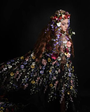 Celtic Bahar Tanrıçası Olarak Kadın Modellerinin Stüdyo Portreleri, Beltane Pagan Mitolojisinden esinlenilmiş Çiçek Fantezi Kostümleri, geri dönüp bakmaktadır. izole Karanlık Stüdyo Arkaplanı