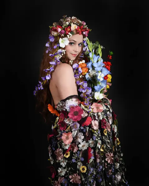 Celtic Bahar Tanrıçası Olarak Kadın Modellerinin Stüdyo Portreleri, Beltane Pagan Mitolojisinden esinlenilmiş Çiçek Fantezi Kostümleri, geri dönüp bakmaktadır. izole Karanlık Stüdyo Arkaplanı