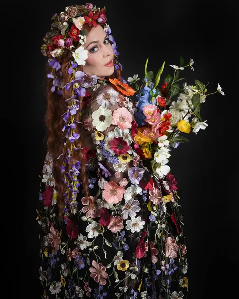 Celtic Bahar Tanrıçası Olarak Kadın Modellerinin Stüdyo Portreleri, Beltane Pagan Mitolojisinden esinlenilmiş Çiçek Fantezi Kostümleri, geri dönüp bakmaktadır. izole Karanlık Stüdyo Arkaplanı