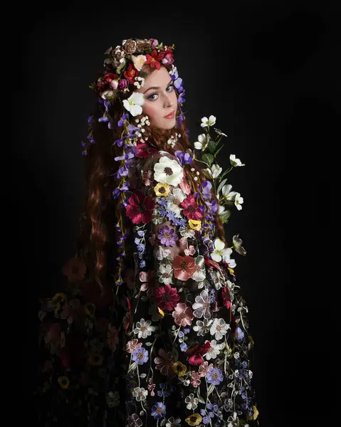 Celtic Bahar Tanrıçası Olarak Kadın Modellerinin Stüdyo Portreleri, Beltane Pagan Mitolojisinden esinlenilmiş Çiçek Fantezi Kostümleri, geri dönüp bakmaktadır. izole Karanlık Stüdyo Arkaplanı