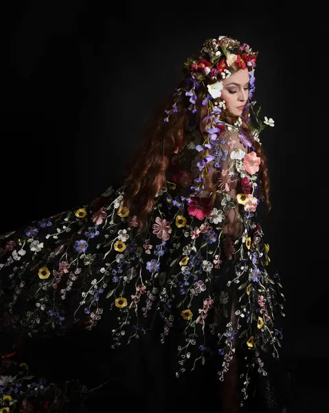 Celtic Bahar Tanrıçası Olarak Kadın Modellerinin Stüdyo Portreleri, Beltane Pagan Mitolojisinden esinlenilmiş Çiçek Fantezi Kostümleri, geri dönüp bakmaktadır. izole Karanlık Stüdyo Arkaplanı