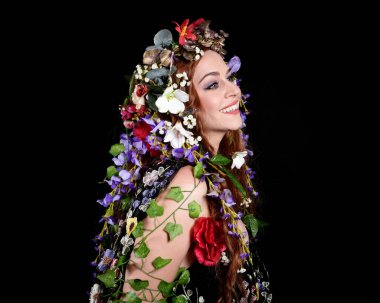 Kelt Bahar Tanrıçası Olarak Güzel Kadın Modeli Portreleri, Beltane Pagan Mitolojisinden esinlenerek Çiçek Fantezi Pelerini Kostümü. izole Karanlık Stüdyo Arkaplanı