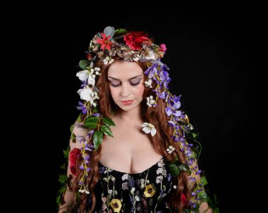 Kelt Bahar Tanrıçası Olarak Güzel Kadın Modeli Portreleri, Beltane Pagan Mitolojisinden esinlenerek Çiçek Fantezi Pelerini Kostümü. izole Karanlık Stüdyo Arkaplanı