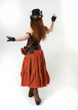 Uzun, yürüyen Steampunk Botanikçisi, çılgın bilim adamı, silindir şapkalı ve gözlüklü kadın model. Kızıl Saçlı Fantezi Karakteri Beyaz Stüdyo Arkaplanında Pozisyon