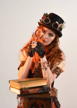 Steampunk Botanikçisi, çılgın bilim adamı, silindir şapkalı ve gözlüklü kadın model. Kızıl Saçlı Fantezi Karakteri Beyaz Stüdyo Arkaplanında Pozisyon