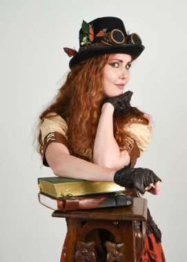 Steampunk Botanikçisi, çılgın bilim adamı, silindir şapkalı ve gözlüklü kadın model. Kızıl Saçlı Fantezi Karakteri Beyaz Stüdyo Arkaplanında Pozisyon