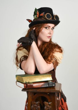 Steampunk Botanikçisi, çılgın bilim adamı, silindir şapkalı ve gözlüklü kadın model. Kızıl Saçlı Fantezi Karakteri Beyaz Stüdyo Arkaplanında Pozisyon