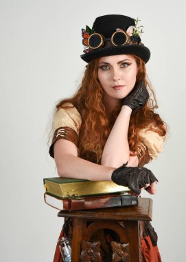 Steampunk Botanikçisi, çılgın bilim adamı, silindir şapkalı ve gözlüklü kadın model. Kızıl Saçlı Fantezi Karakteri Beyaz Stüdyo Arkaplanında Pozisyon