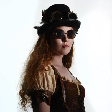 Steampunk Botanikçisi, çılgın bilim adamı, silindir şapkalı ve gözlüklü kadın model. Kızıl Saçlı Fantezi Karakteri Beyaz Stüdyo Arkaplanında Pozisyon