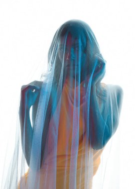 Kadın modelin siluetli arka ışıklandırmalı portreleri katıksız kefen örtüsüyle örtülmüş, hafif ışıklandırmayla parlayan. Gizemli, karamsar ve dramatik fantezi veya gotik temalar için mükemmel..