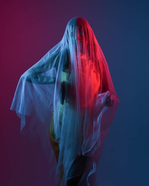 Saf kefen örtüsüne sarılı bir kadın modelin portreleri, canlı neon pembe ve mavi ışıkla aydınlatılıyor, karamsar, rüya gibi ve görsel olarak çarpıcı seriler yaratıyor, ruhani ışıkla kalın rengi harmanlıyor..