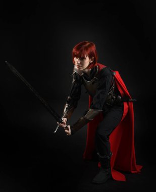 Tarihsel ortaçağ zırhlı fantezi savaşçı kadın modeli, kırmızı peri masalı pelerini, güçlü bir fantezi şövalyesinin kılıç tutan sinematik portresi. Destansı duruş, karanlık stüdyo arkaplan