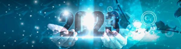 Businessman hand holding 2023 number,happy new year concept digital trends,industry and business trend,world full modernity advanced technology,artificial intelligence or AI,banner header panoramic