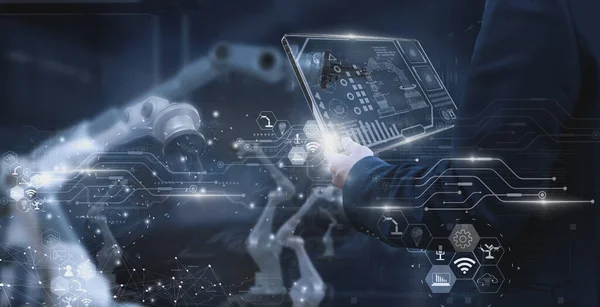 工厂工业工程师 使用智能平板玻璃装置 控制自动化机械臂学习操作 概念业务和工业4 人工智能或人工智能 带有5G网络 免版税图库图片