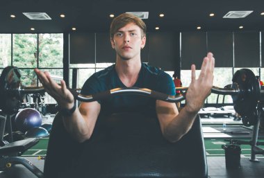 Spor salonunda halter egzersizi yapan yakışıklı bir erkek sporcu, spor salonunda beden eğitimi alırken spor yaparken, spor yaparken mutlu, konsept yakma fazla vücut, antrenörlerin planladığı egzersizler...