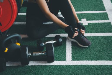 Spor salonunda halter egzersizi yapan kadın sporcu, spor salonunda beden eğitimi alırken spor yaparken, spor yaparken mutlu, konsept yakma fazla vücut, antrenörlerin planladığı egzersizler...
