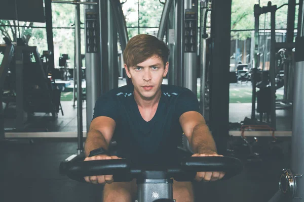 Men are exercising happily on bicycle machine in the fitness gym to exercise with the concept of strengthening the body for lasting and disease-free health and a hansom body and slim