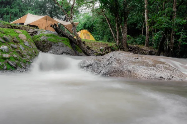 Equipment campground Outdoor camping picnic group waterfall zone, natural camping area landscape background, with trees and green grass, summer trip relax and holiday Adventure Travel concept.