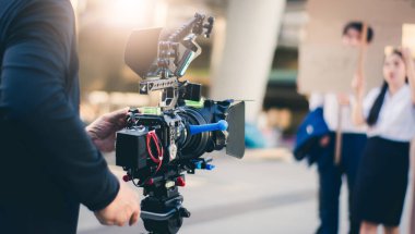 Bir video kamera filmi ve TV reklamı ile çekim ekipmanları, sahne arkasında video çekimi doğa arka planı.