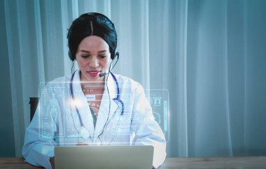Siyahi kadın doktor, uzman masası ve kulaklığı, hastalara ve halka danışmanlık ve hastalık danışmanlığı, internet üzerinden teletıp hizmeti, hastaneden eve internet iletişimi.