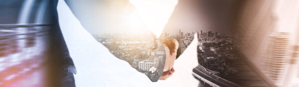 Mixed media effect Double exposure businessman handshake business deal to partner successfully negotiated and commercial cooperation and trade cityscape blurred background panoramic header banner