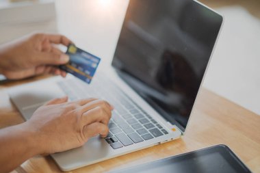 Bilgisayarlı alışveriş, ev ya da iş yerinde online ödeme, internet bankacılığı, ürün siparişi veren girişimciler veya harcamalar için gelecekteki yaşam tarzı fikirleri kullanarak kredi kartını kapatan adam elleri