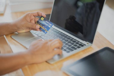 Bilgisayarlı alışveriş, ev ya da iş yerinde online ödeme, internet bankacılığı, ürün siparişi veren girişimciler veya harcamalar için gelecekteki yaşam tarzı fikirleri kullanarak kredi kartını kapatan adam elleri