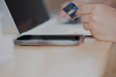 Bilgisayarlı alışveriş, ev ya da iş yerinde online ödeme, internet bankacılığı, ürün siparişi veren girişimciler veya harcamalar için gelecekteki yaşam tarzı fikirleri kullanarak kredi kartını kapatan adam elleri