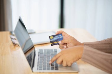 Bilgisayarlı alışveriş, ev ya da iş yerinde online ödeme, internet bankacılığı, ürün siparişi veren girişimciler veya harcamalar için gelecekteki yaşam tarzı fikirleri kullanarak kredi kartını kapatan adam elleri