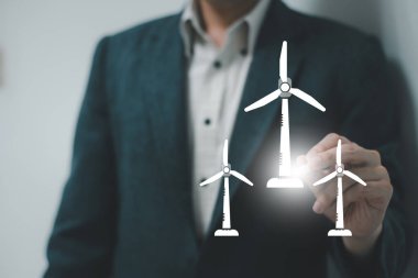 İş dünyası lideri dizüstü bilgisayarında rüzgar ve güneş ikonları ile sürdürülebilir enerji yönetiyor. 