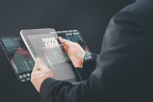 2025 год для развития бизнеса и концепции индустрии, бизнесмен использует компьютер с символьной стрелкой вверх, фондовый график и графики фон, инвестиции, фондовый рынок и стратегию для составления рыночного плана.