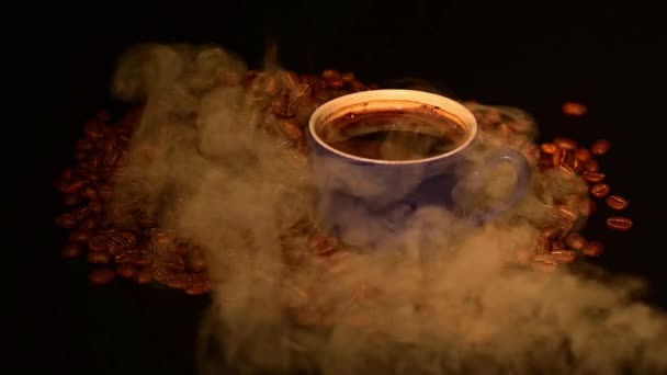 軽い煙の中でローストコーヒー豆の間のコーヒーカップ Hdビデオとスローモーション — ストック動画