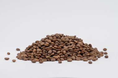 Beyaz arka planda kahve çekirdeği yığını, reklam için yer, kavrulmuş kahve çekirdekleri..