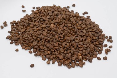 Aromatik ve kavrulmuş kahve çekirdekleri beyaz arka planda, yazıtlar ve reklamlar için yer, bağımlılık yapan içecekler..