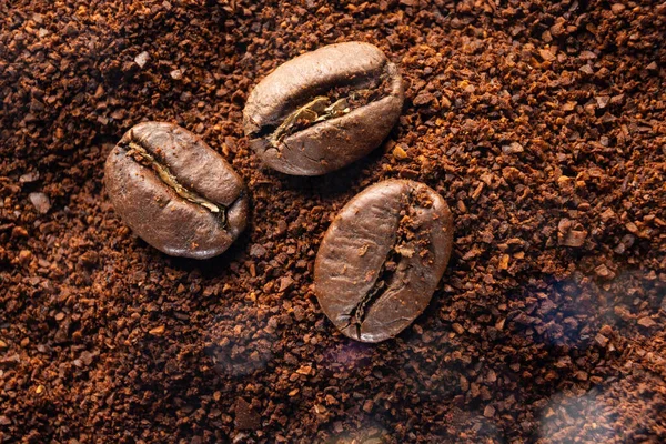 Tre Kaffebönor Ligger Malet Kaffe Närbild Rostat Och Malet Kaffe — Stockfoto