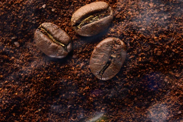 Trzy Ziarna Kawy Leżą Mielonej Kawie Lekki Aromatyczny Dym Kawy — Zdjęcie stockowe