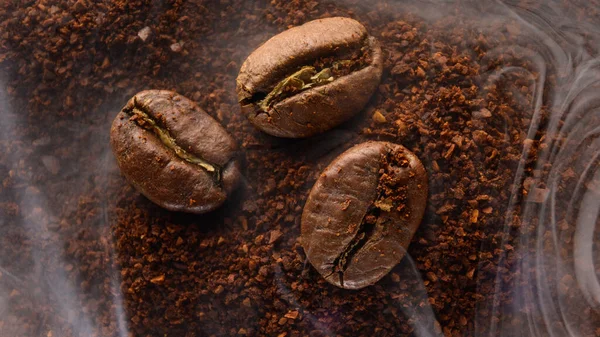 Tři Kávová Zrna Leží Mleté Kávě Lehké Aromatické Kávy Kouř — Stock fotografie